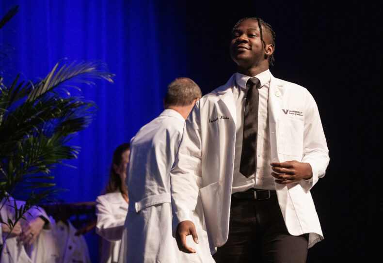 Ezechukwu Nduka of La Crosse, Wisconsin, walks across the stage during the White Coat Ceremony. (photo by Erin O. Smith)