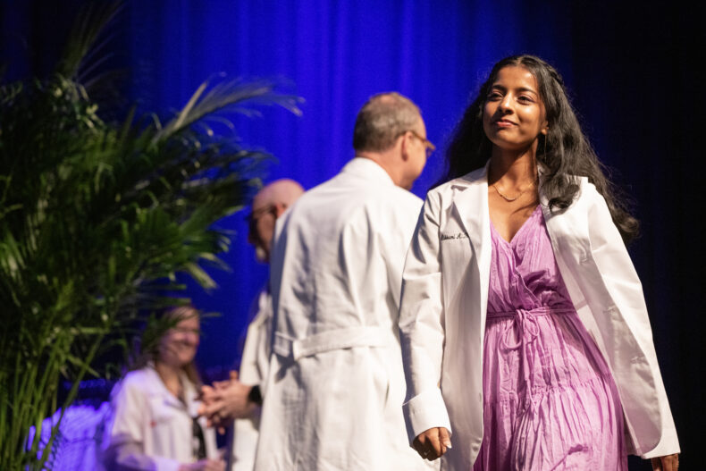 Abhirami A. Thaivalappil smiles after receiving her white coat. (photo by Erin O. Smith)