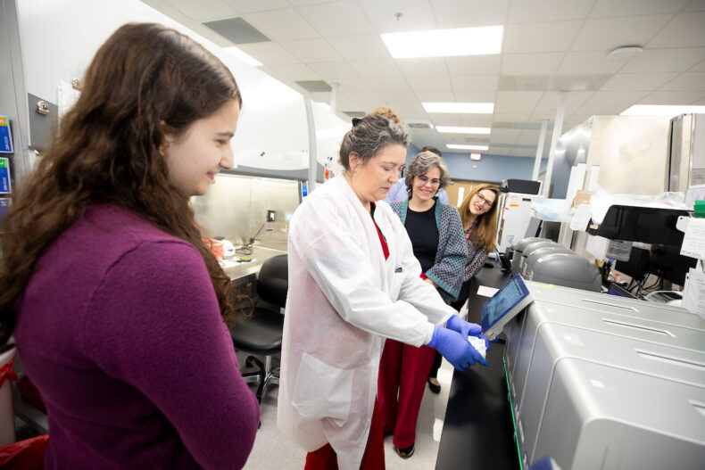 008 - Sharon Glover, Medical Laboratory Scientist, shows Maggie Weiss how to conduct a respiratory virus test during a tour of the Vanderbilt Medical Laboratories. (photo by Susan Urmy)