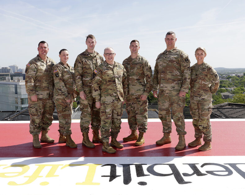 McQueen posed on the LifeFlight helipad with some of the AMCT3 members now working at VUMC: Douglas Low, RN, Emergency Medicine; Shannon Martin, Emergency/LifeFlight paramedic; Joshua Smith, assistant professor of Clinical Surgery; Michael Derickson, assistant professor of Clinical Surgery; Christopher Bickett, assistant professor of Emergency Medicine; and Kayla Hearn, RN, Critical Care. (Photo by Donn Jones)