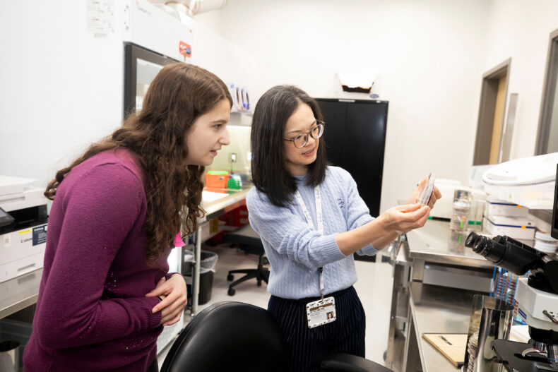 Lili Tao, MD, PhD, medical director of Mycology and Immunoserology, shows Maggie Weiss a culture plate on which the fungus that causes histoplasmosis is growing. (photo by Susan Urmy)