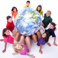Nine students sitting on the floor in a circle around a large globe. ell_00_init