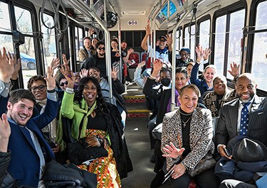 group of people sitting on a WeGo bus waving at camera