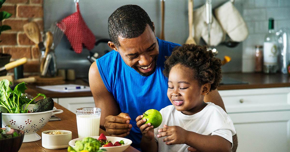 father and son eating fruit