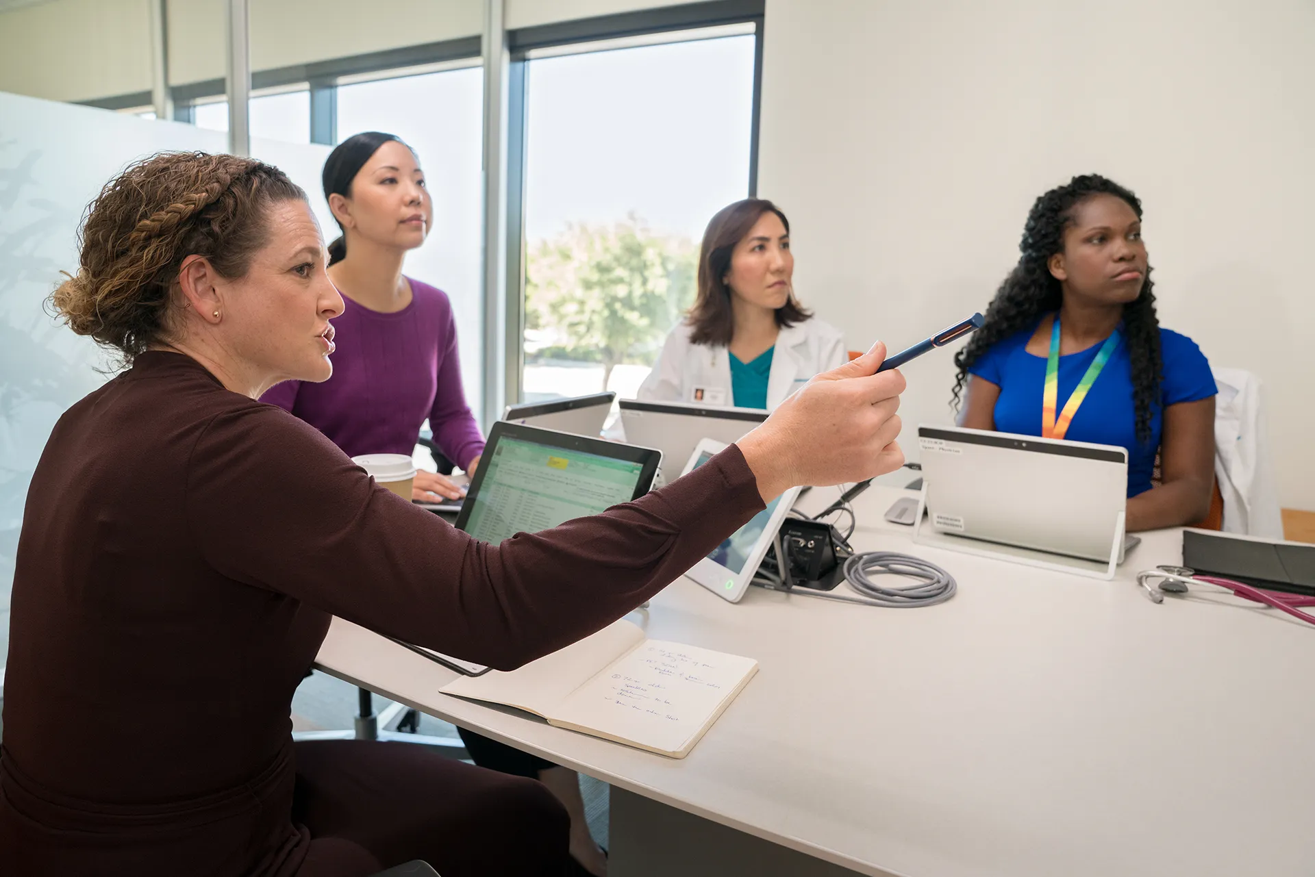 Doctors and Researchers meeting around desk with laptops