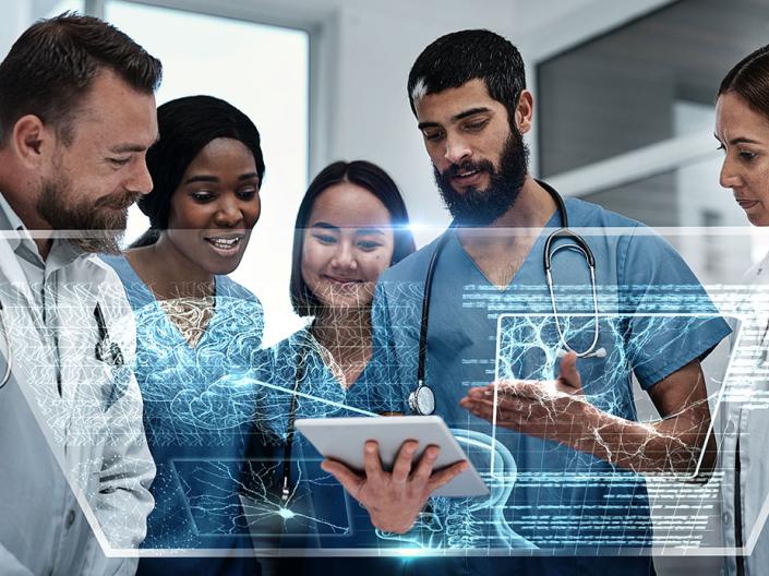 A group of five medical professionals view a 3D holographic overlay from a tablet.