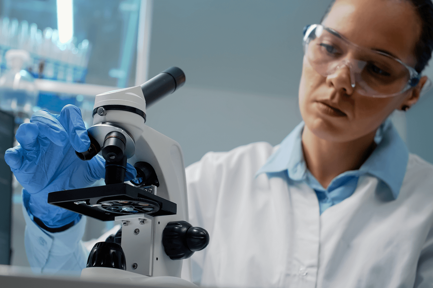 Scientist using a microscope in a laboratory setting to conduct research and analyze samples.