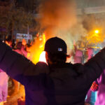 a crowd around a fire at night