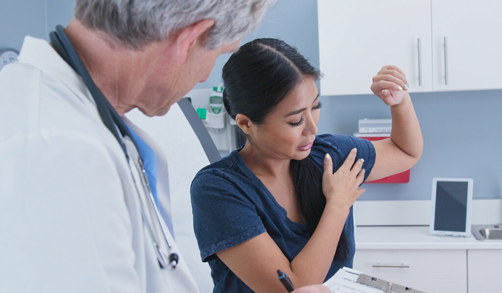 Woman with doctor showing shoulder pain