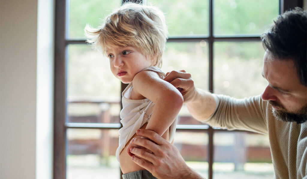 Father with young son checking arm circumference