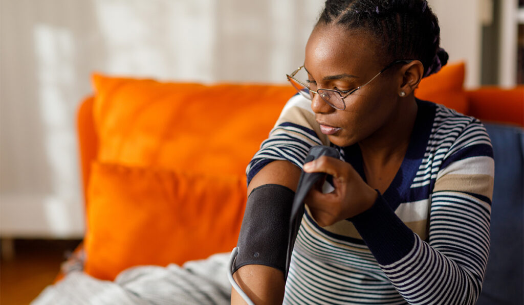 Young woman checking blood pressure at home