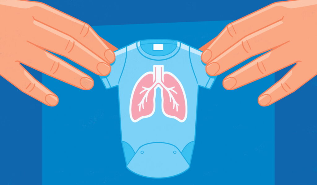 Hands holding a tiny onesie with lungs pictured on the front