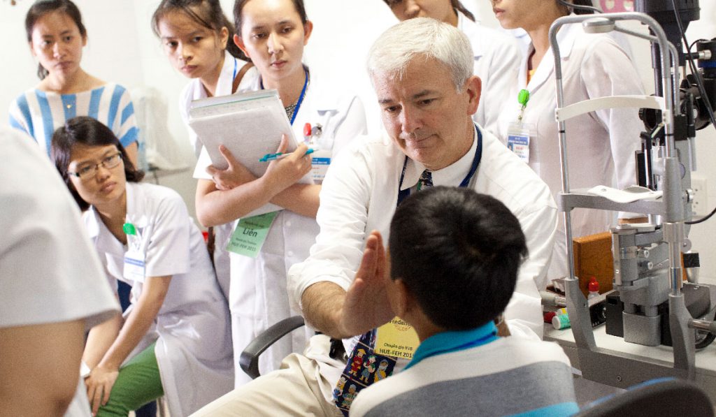 Surgical students with mentor examining pediatric patient