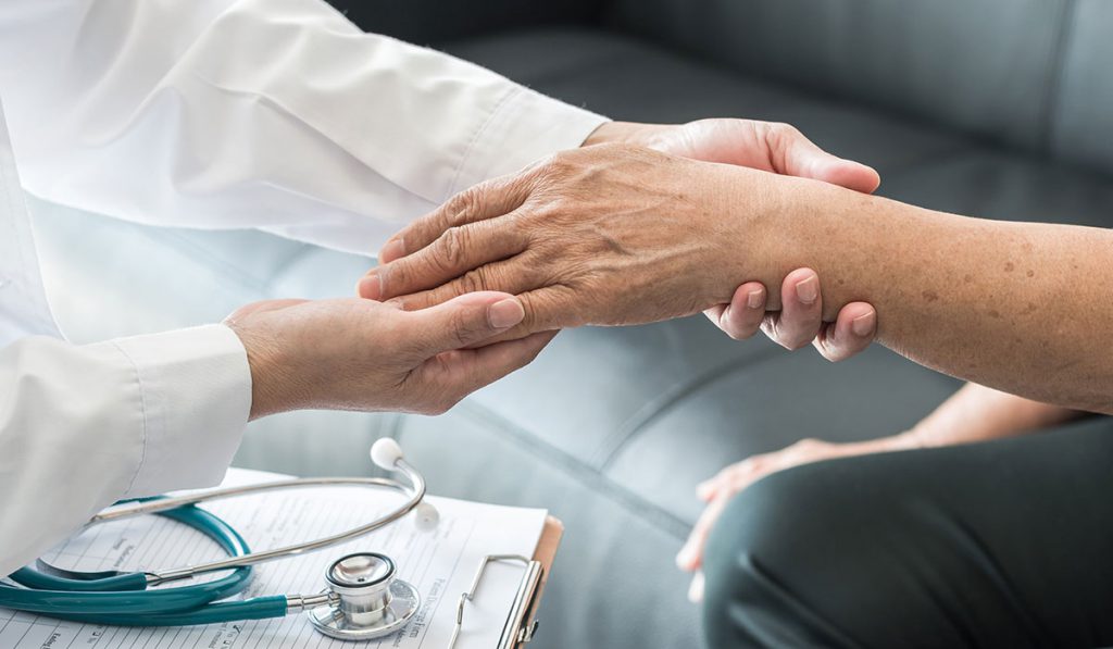Healthcare provider examining patient's hand and forearm