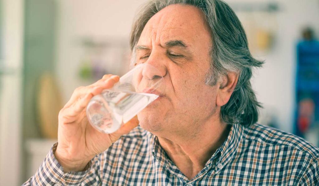 Older man drinking water
