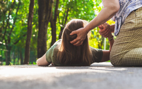 Woman helping fallen girl