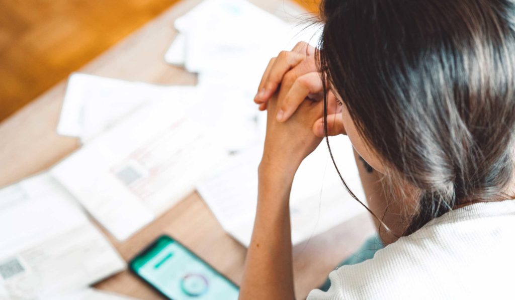 Healthcare patient struggling with invoices and financial toxicity.