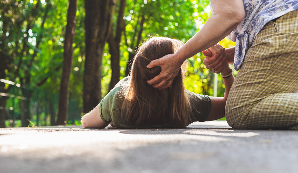Woman helping fallen girl