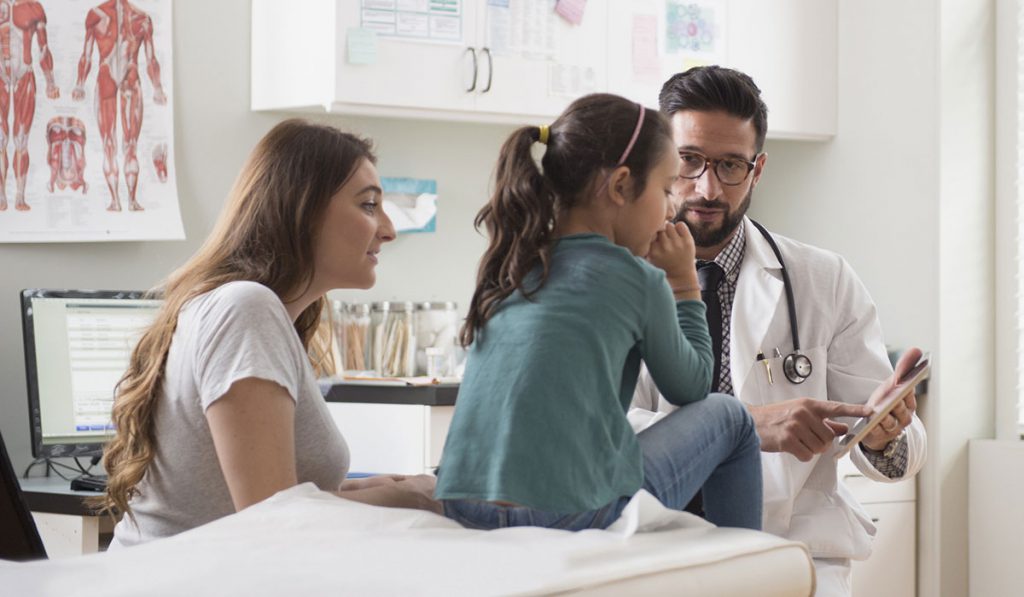 Physician reassuring pediatric patient and mother