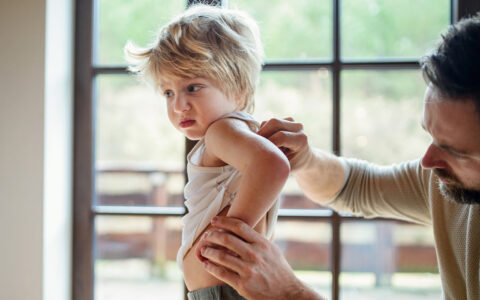 Father with young son checking arm circumference