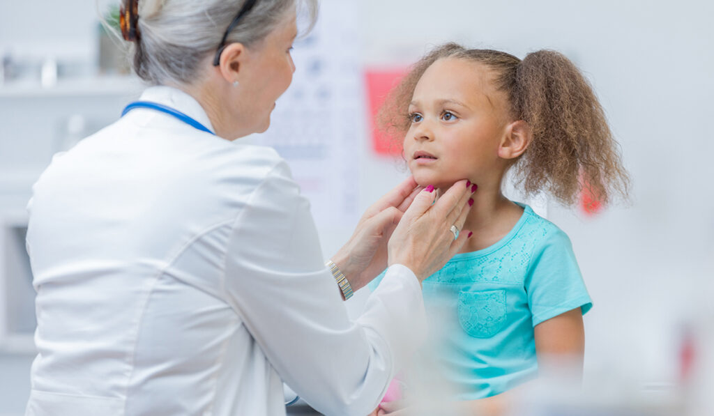 Doctor palpating neck of child