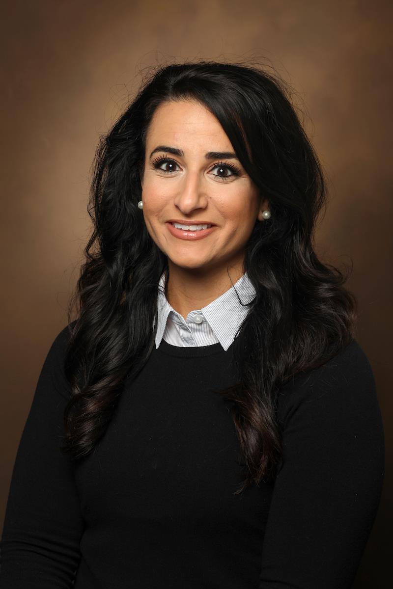 Portrait of Elizabeth Rendina-Ruedy, Ph.D., a woman with dark hair in a black sweater and white collared shirt