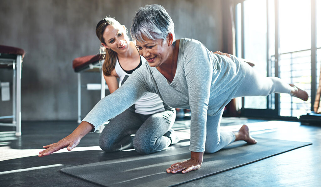 Health coach helping woman do ab exercises