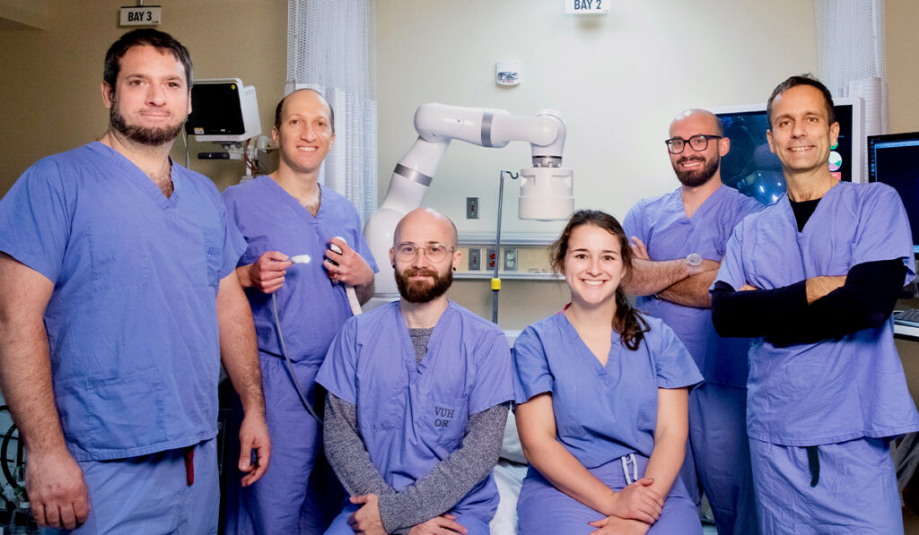 Keith Obstein, M.D., M.P.H., with a group of other doctors in front of a robotic colonoscopy device