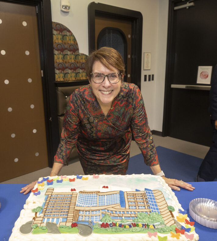 Meg Rush, MD, MMHC, at the reception with a cake depicting Monroe Carell Jr. Children’s Hospital at Vanderbilt (photo by Susan Urmy)