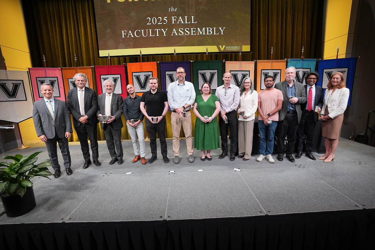 A group of people standing on a stage holding awards