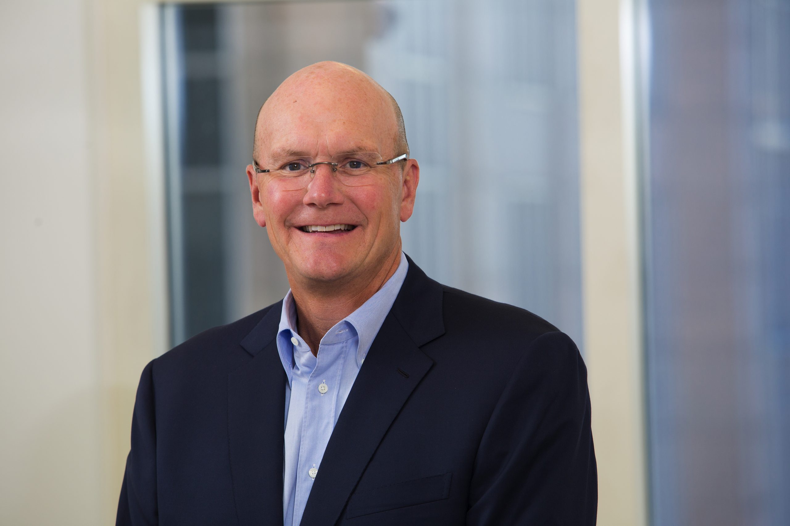 A headshot of a man wearing glasses