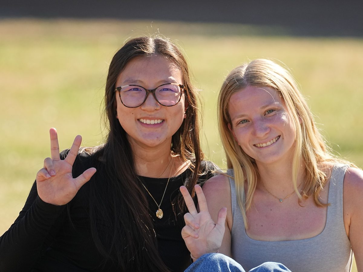 students smiling with Vanderbilt hand sign 