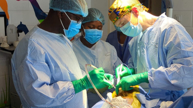 Michael Dewan, MD, assistant professor of Neurological Surgery, works with surgeons during a procedure in Monrovia, Liberia.