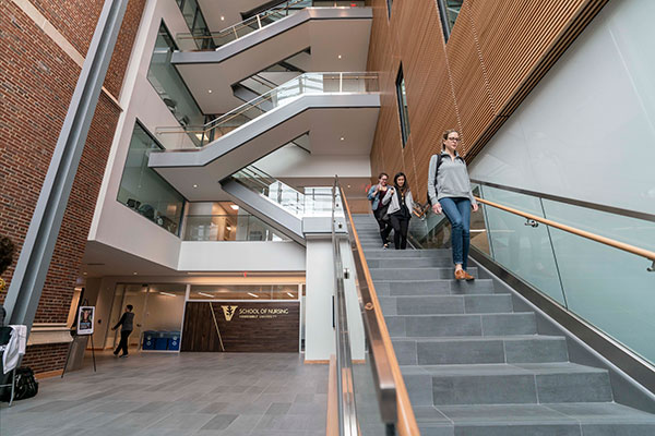 Inside CCW Atrium with focus on the stone stairs. Students are walking down them.
